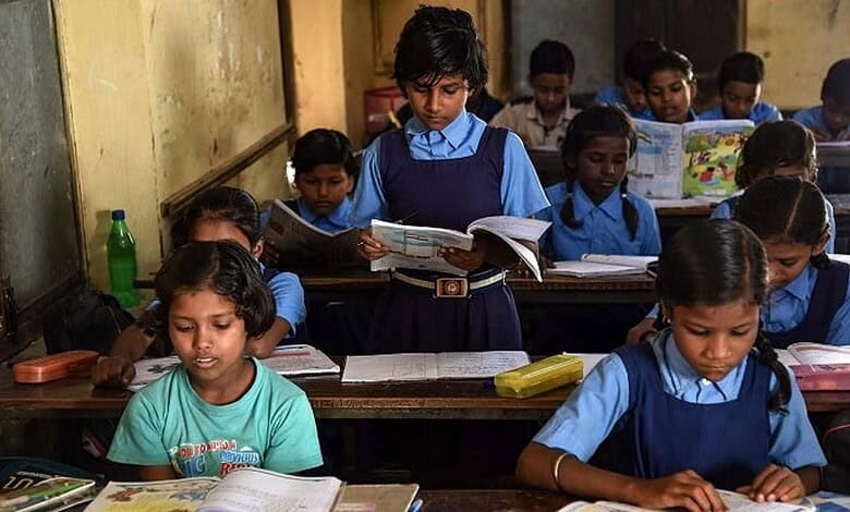 A girl reads out a passage to students; the students follow the passage line by line in the textbooks.