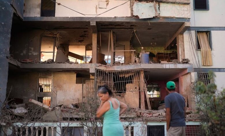 Residents look at a damaged apartment complex that neighbours say was hit during US strikes to capture Venezuelan President Nicolás Maduro in Catia La Mar of Venezuela on Sunday. (AP/PTI)