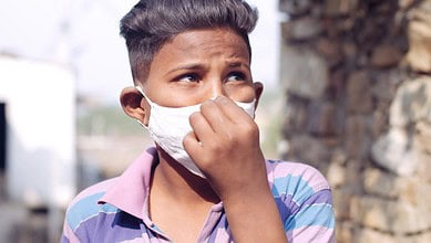 young South Asian child fixing Mask