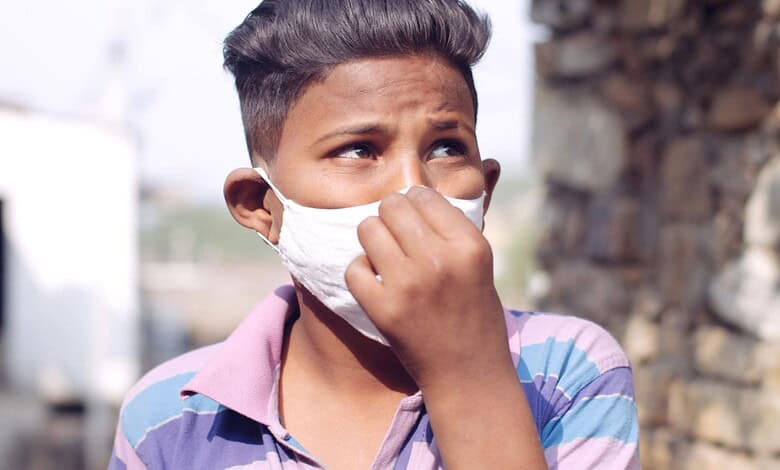 young South Asian child fixing Mask