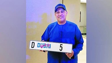 Indian businessman Abu Sabah holding Dubai number plate 5 after auction purchase.