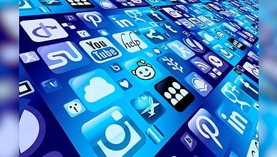 Image shows A collection of blue-tinted social media and app icons displayed in a perspective grid layout on a digital screen.