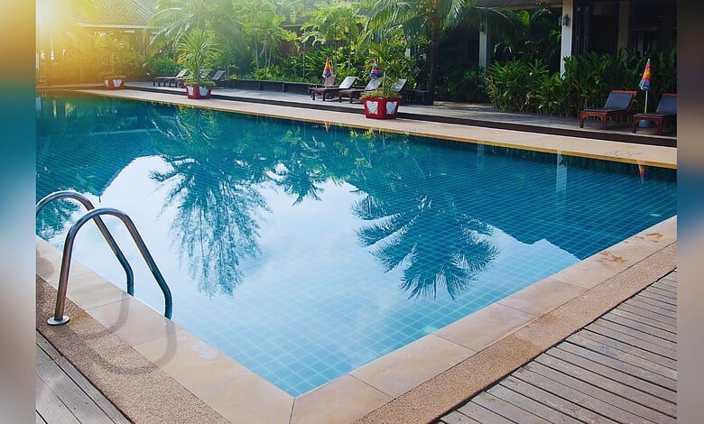 Image shows a swimming pool with trees in the background