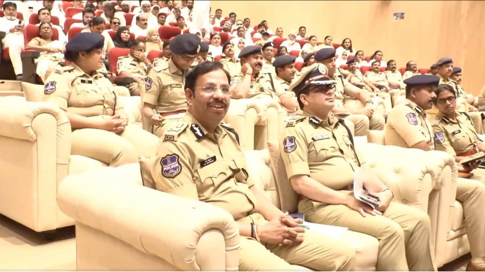 Police officers attending a formal event in uniform at a conference or ceremony.