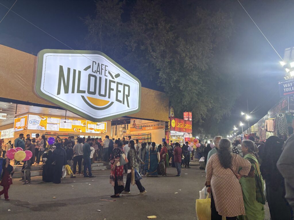 Crowds gather outside Café Niloufer during Hyderabad Numaish event at night.