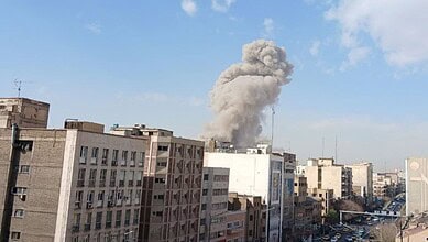Explosion and smoke rising over Tehran city skyline during pre-emptive strikes.