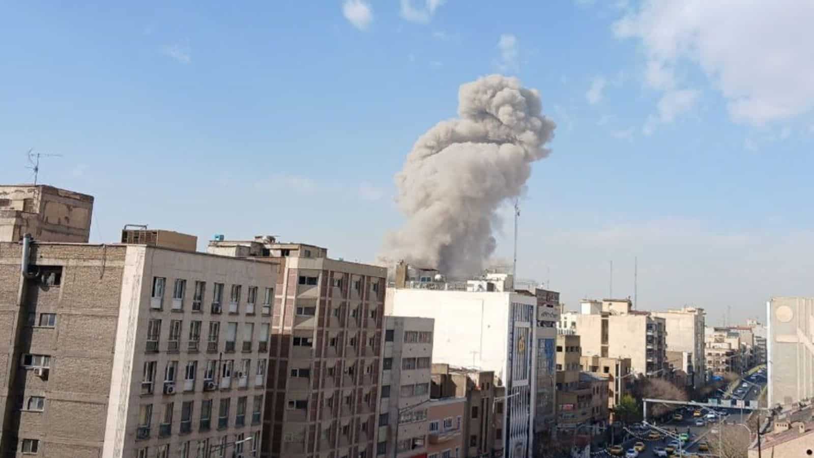 Explosion and smoke rising over Tehran city skyline during pre-emptive strikes.