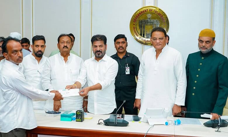 The image shows Telangana CM A Revanth Reddy handing-over ex-gratia cheques to the kin of Madina bus accident victims at Telangana Secretariat on Saturday, February 28, 2026.