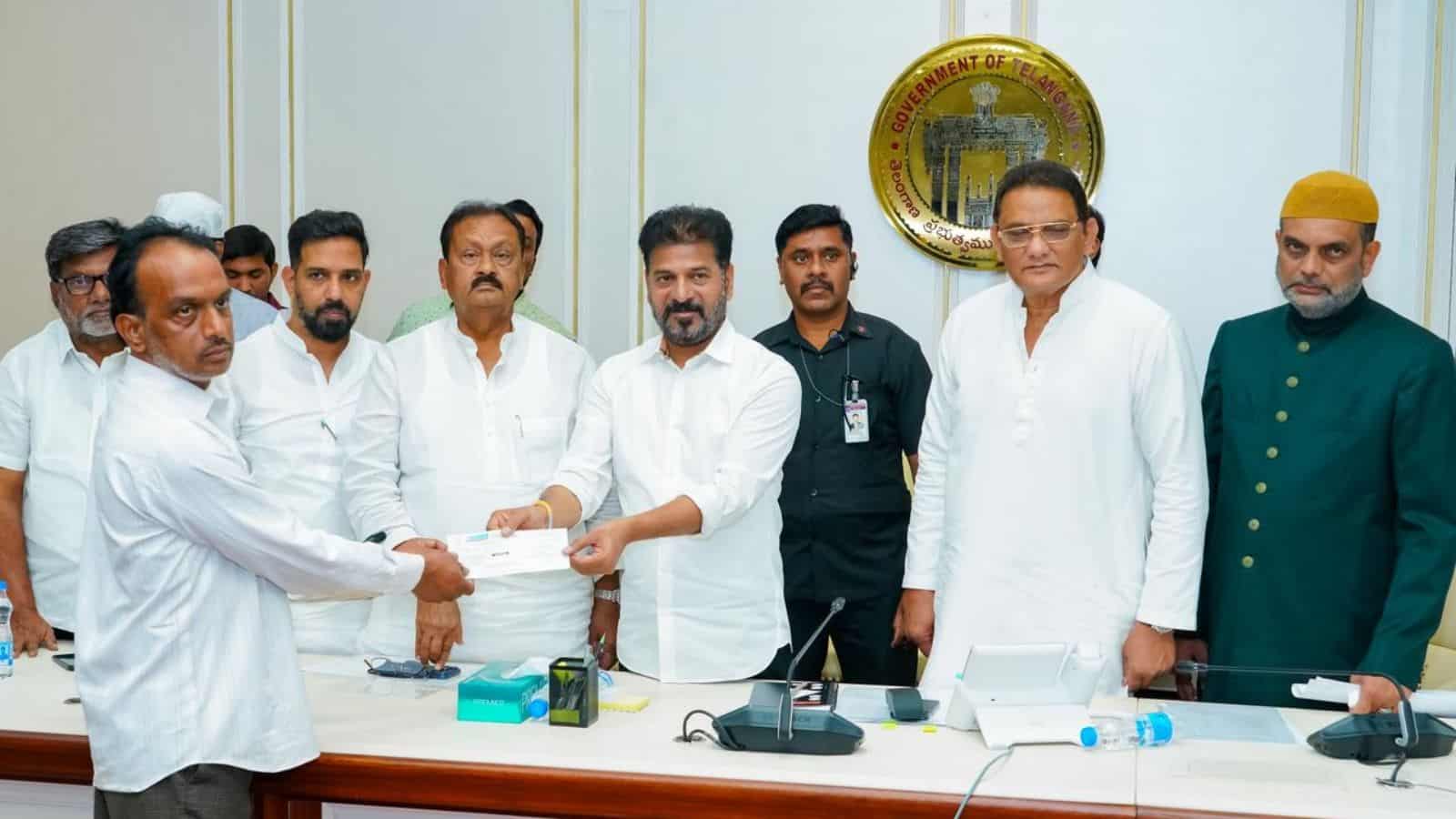 The image shows Telangana CM A Revanth Reddy handing-over ex-gratia cheques to the kin of Madina bus accident victims at Telangana Secretariat on Saturday, February 28, 2026.