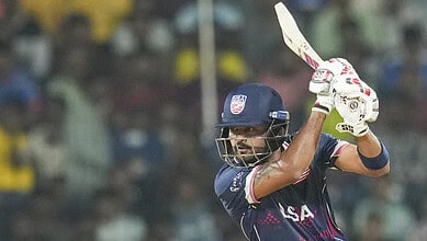 Cricket player in USA team batting at T20 World Cup match.
