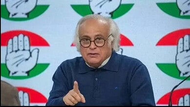 Indian Prime Minister Modi speaking at a political event with Congress symbols in the background.