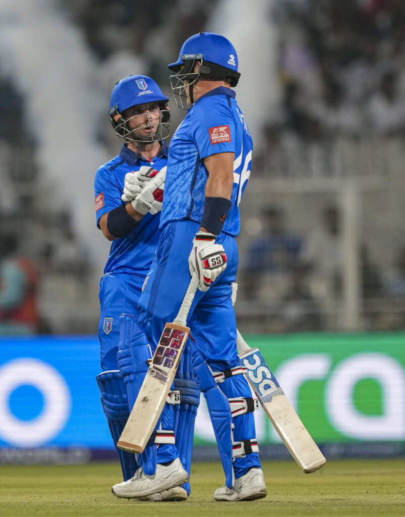 Indian cricket players celebrating during a match in blue uniforms.