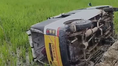 Upside-down bus carrying school students after accident in Telangana, with visible damage and overturned.