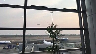 Interior view of Hyderabad airport with planes on the tarmac, highlighting its recognition in global pass.