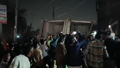 Bystanders take pictures after a building collapses in Kota, Rajasthan