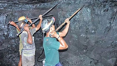Mining workers inspecting a dark underground tunnel with tools and helmets.