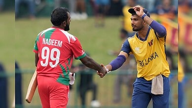 Sri Lanka's captain Dasun Shanaka, right, and Oman's Mohammad Nadeem shake hands after Sri Lanka won the T20 World Cup cricket match against Oman in Pallekele