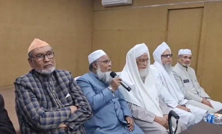 Prominent Muslim leaders participating in a discussion at a formal event in a conference room.