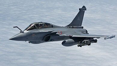 Rafale fighter jet flying over clouds, showcasing India's military strength and defence capabilities.