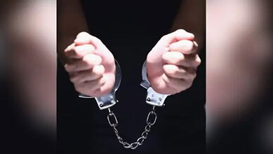 Arrested man in handcuffs, handcuffs linked with chain, close-up image.