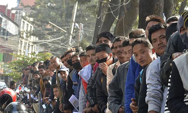Crowd of young voters participating in Nepal election campaign, many wearing masks and holding campa.