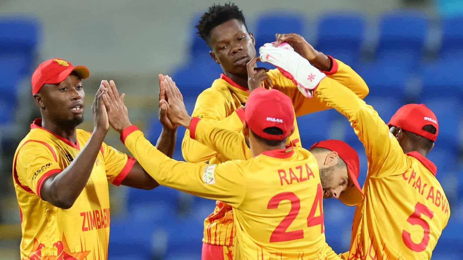 Zimbabwe cricket team celebrating after a match, players in yellow and red uniforms.