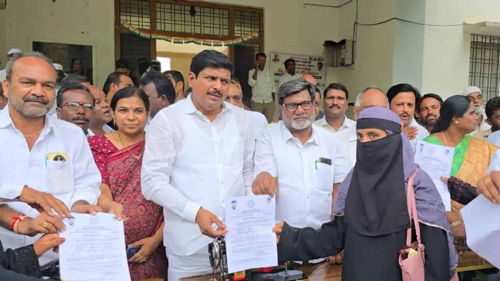 Telangana government hands over cheques and mopeds to minority beneficiaries.