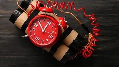 Alarm clock with a bomb threat prank, red clock face and dynamite sticks, symbolising danger during.