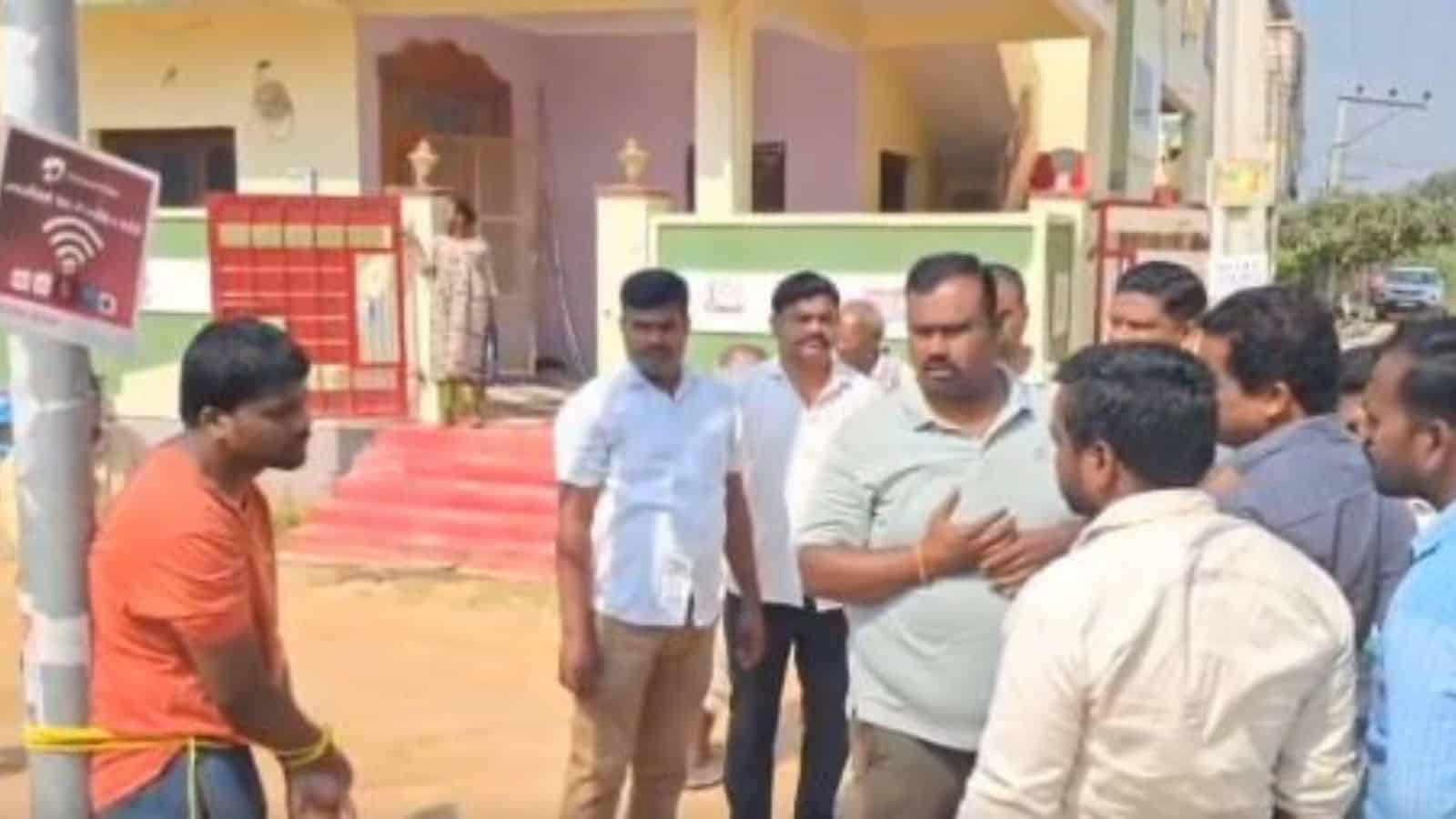 Man arguing with a group of men in Telangana after a violent incident.