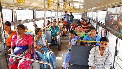 Passengers seated inside a bus with Mahalakshmi smart cards for free travel.