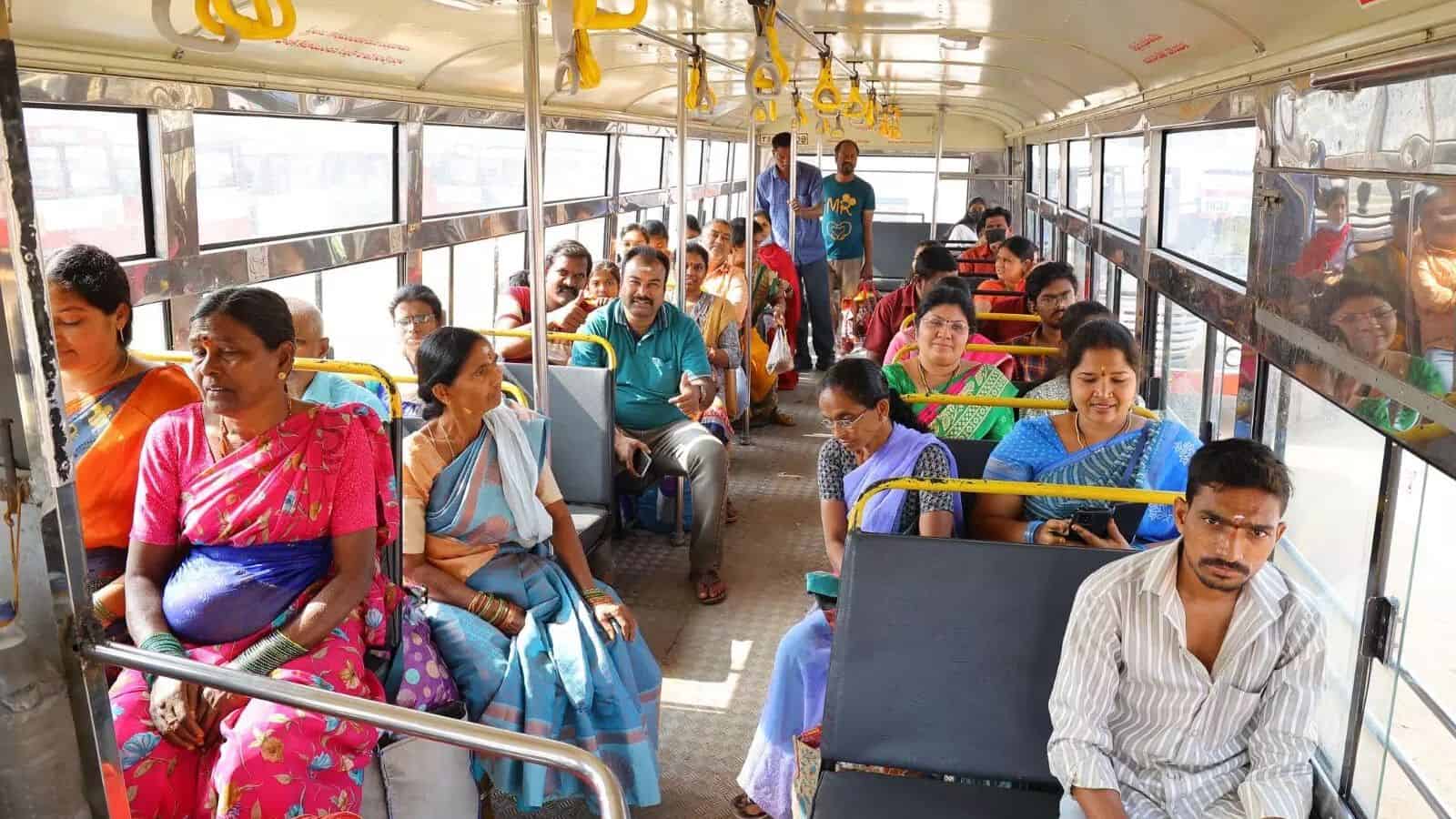 Passengers seated inside a bus with Mahalakshmi smart cards for free travel.
