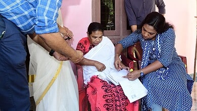 Officials reviewing electoral documents with voters in Kerala for final voter list update.
