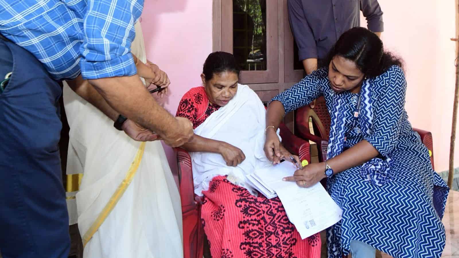 Officials reviewing electoral documents with voters in Kerala for final voter list update.