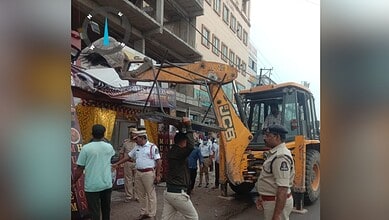 Construction machinery on busy street with police officers and pedestrians.