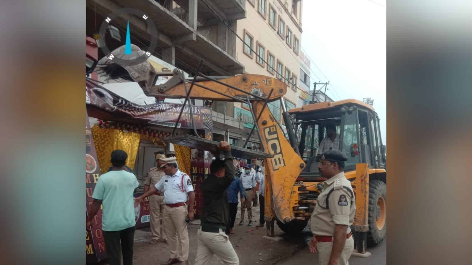 Construction machinery on busy street with police officers and pedestrians.