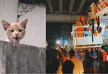 Construction workers operating a crane at night in a busy city setting.