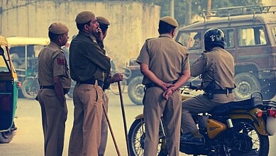 Police officers and a woman on a motorcycle in an urban setting.