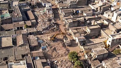 Demolition drive in Rajkot with heavy machinery tearing down 1,489 houses, marking the end of the clearan.