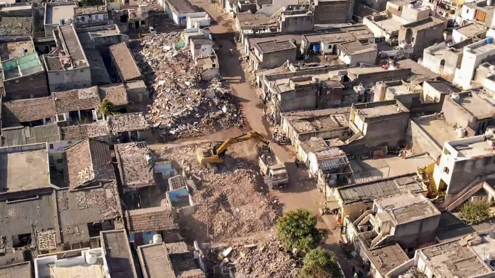 Demolition drive in Rajkot with heavy machinery tearing down 1,489 houses, marking the end of the clearan.