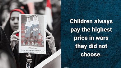 Woman holding a protest sign with children’s photo during rally for peace and justice.