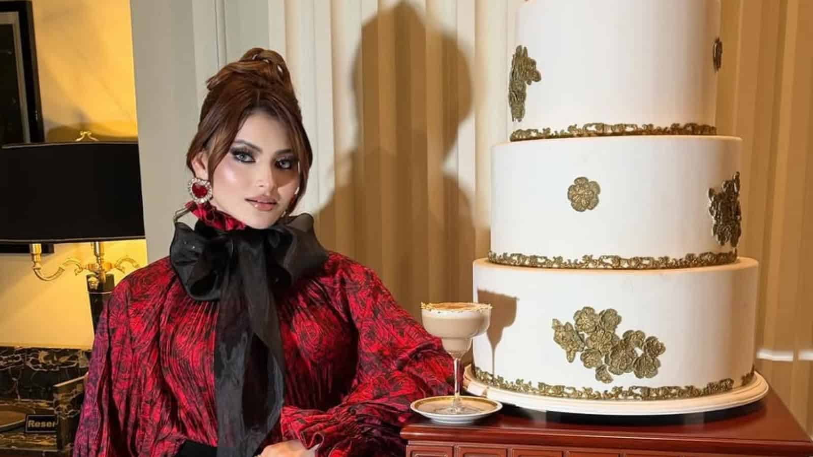 Expensive cake worth Rs 16 crore with gold accents, displayed with a woman in elegant attire.