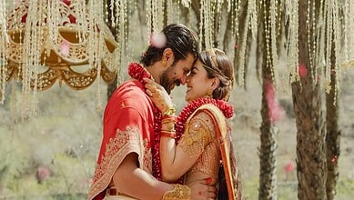 Vijay and Rashmika share a joyful moment at their wedding, surrounded by traditional decorations and flor.