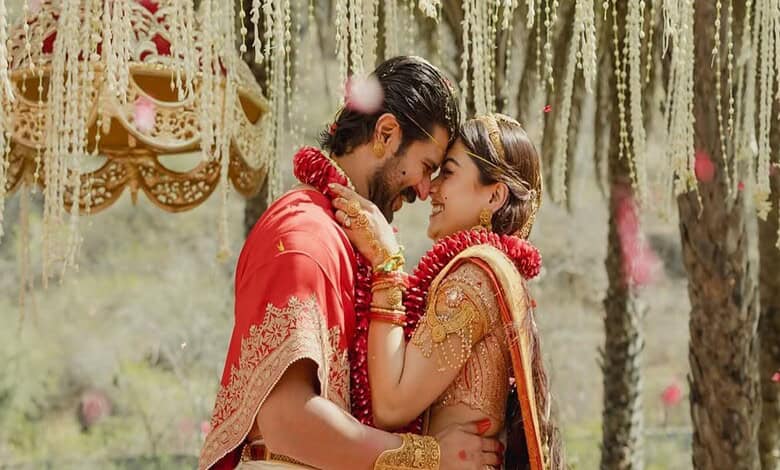 Vijay and Rashmika share a joyful moment at their wedding, surrounded by traditional decorations and flor.