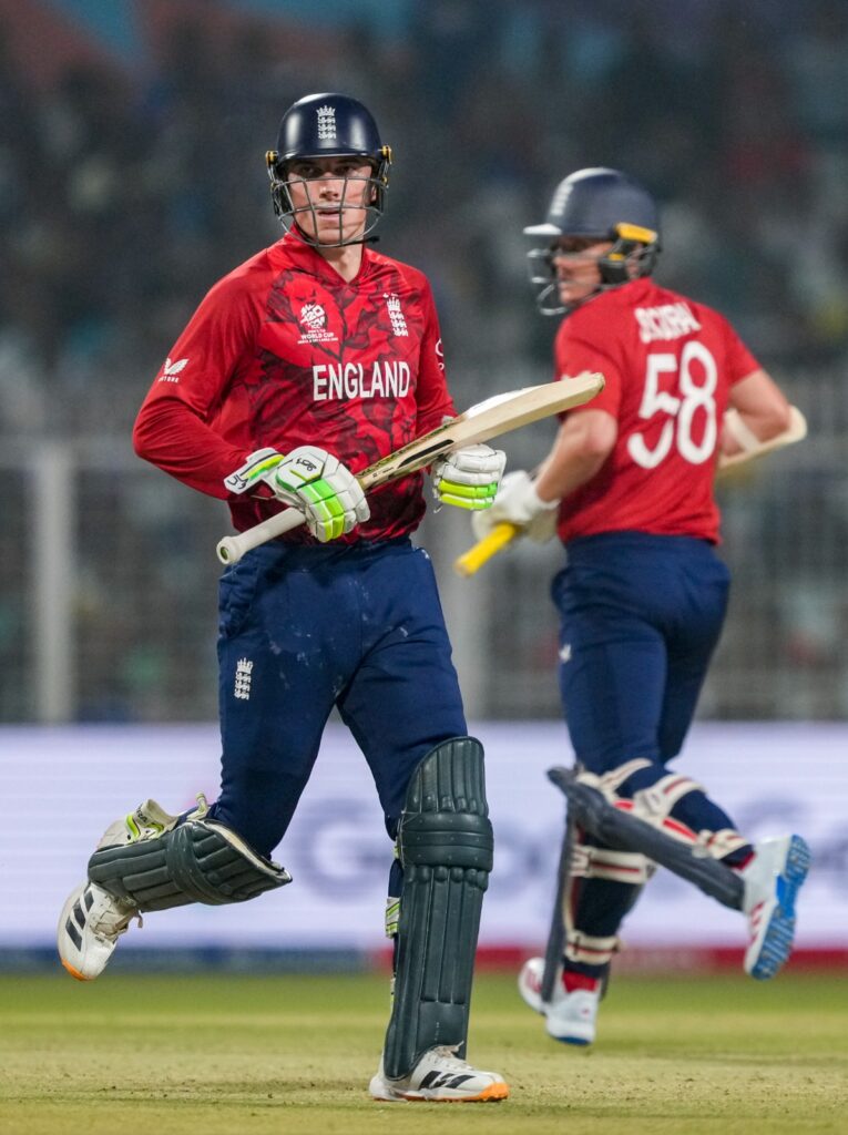 England cricket players in red jerseys on the field.