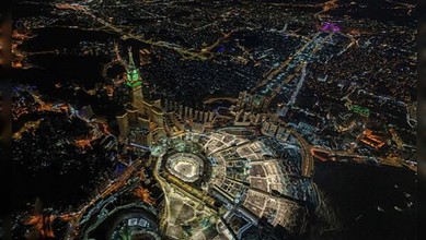 Aerial view of a vibrant city at night showcasing bright lights and urban development.