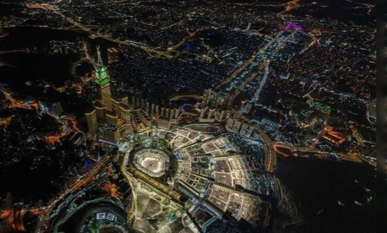 Aerial view of a vibrant city at night showcasing bright lights and urban development.