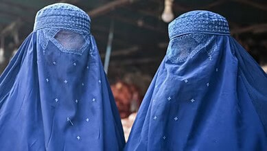 Burqa-clad Afghan women at a market in Kabul, December 2021