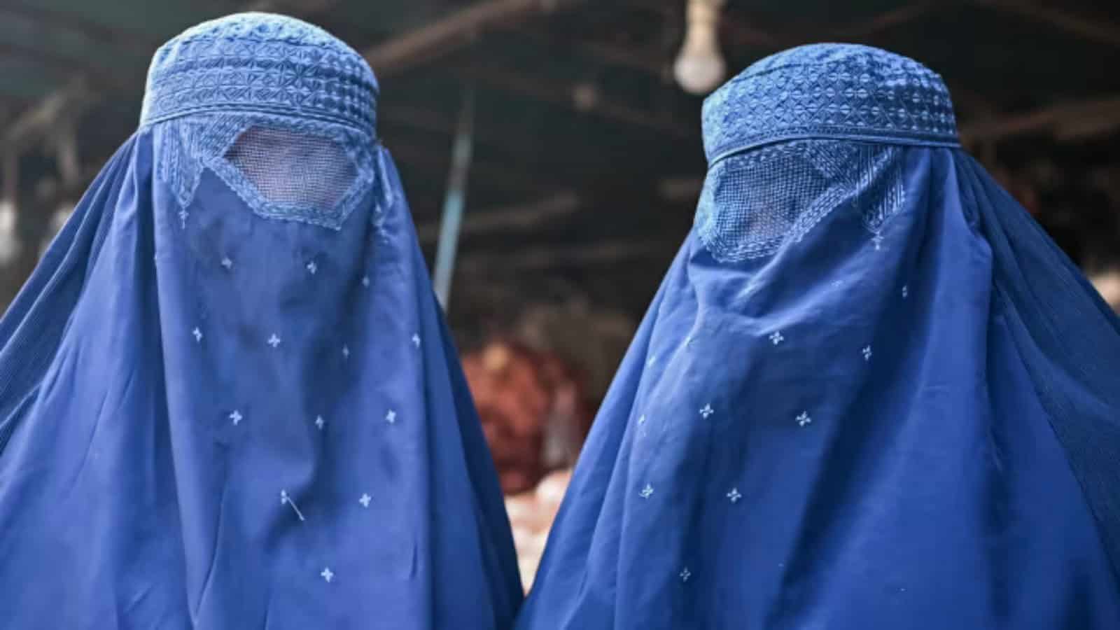 Burqa-clad Afghan women at a market in Kabul, December 2021