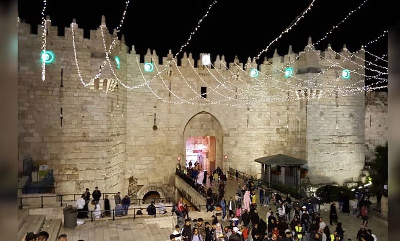 Night view of Jerusalem walls decorated with lights during Ramadan festivities.