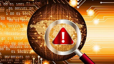 An image depicting a cybersecurity operation with a magnifying glass highlighting a warning symbol, representing a crackdown on cyber threats.